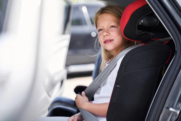 Sorrindo menina sentada no carro da criança sentar — Fotografia de Stock