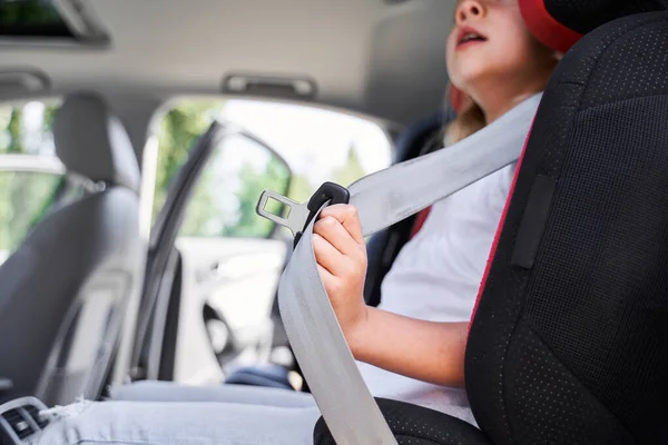 Klein meisje met veiligheidsgordel in autostoel — Stockfoto