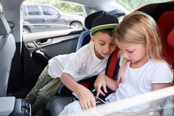 Crianças felizes jogando no tablet no carro — Fotografia de Stock