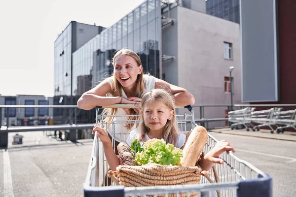 Alegre madre con hija visitando el supermercado juntos —  Fotos de Stock