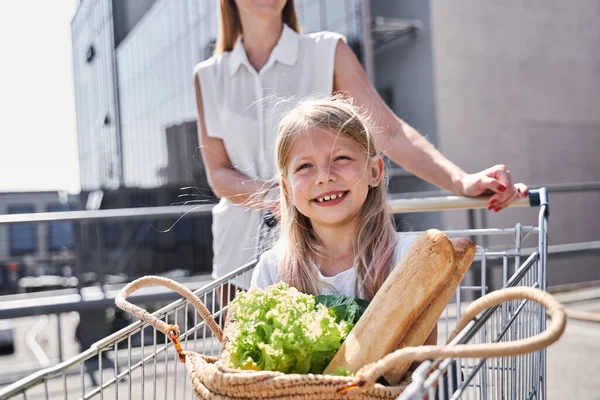 Feliz niña disfrutando de ir de compras con madre cariñosa —  Fotos de Stock