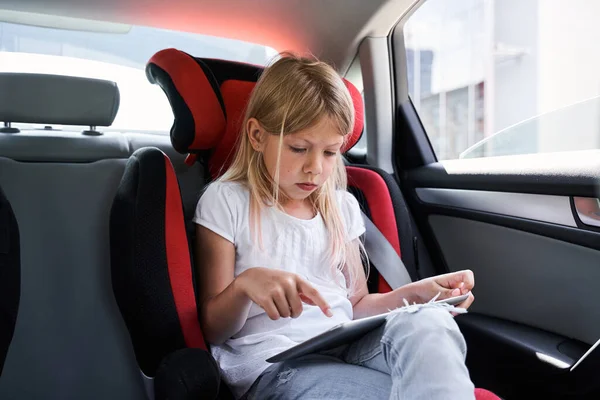 Menina bonito usando tablet no carro — Fotografia de Stock