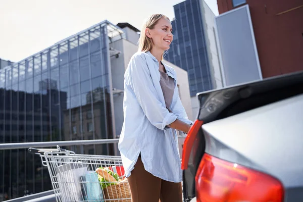 Счастливая молодая женщина за рулем автомобиля в супермаркет — стоковое фото