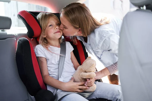 Счастливая женщина обнимается с дочерью в машине — стоковое фото