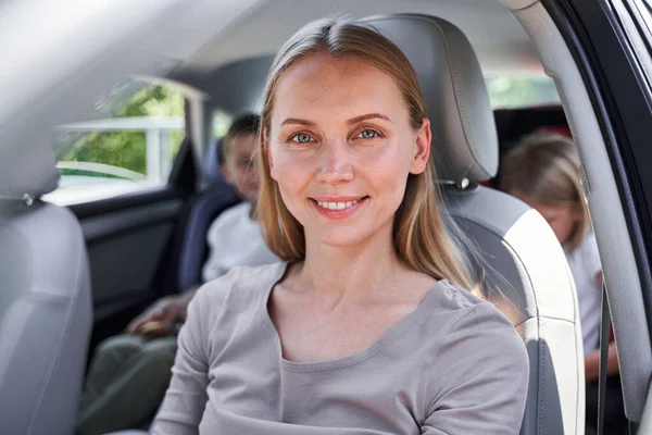 Χαρούμενη νεαρή γυναίκα που οδηγεί μαζί με παιδιά. — Φωτογραφία Αρχείου
