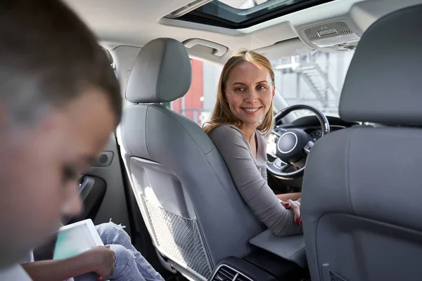 Niños viajando con gadgets y mamá en coche — Foto de Stock