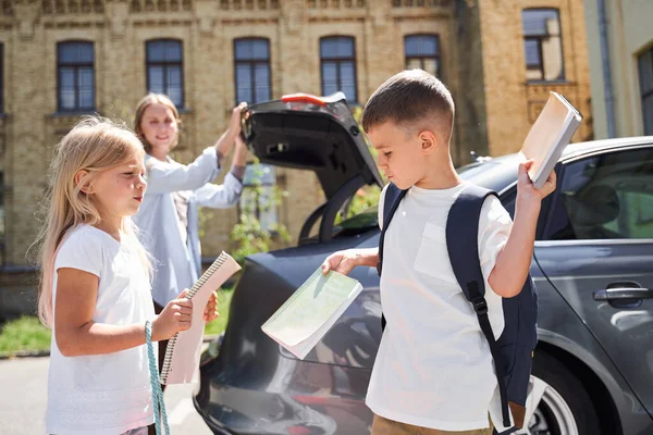 Feliz irmãos se divertindo perto do carro da família — Fotografia de Stock