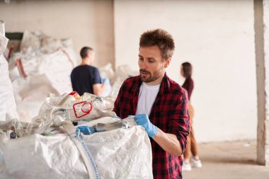Atık geri dönüşüm fabrikasında çalışan bir adam.
