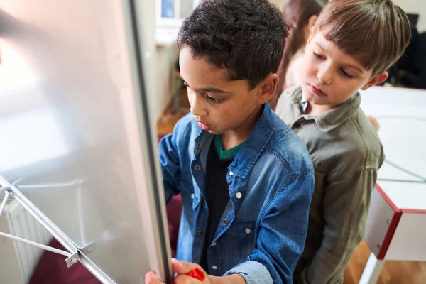 Two classmates standing near to each other and studying