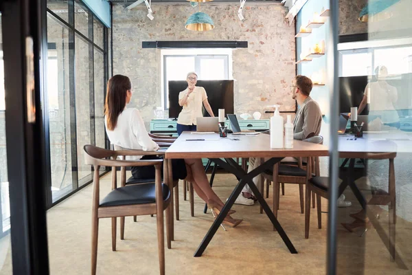 Tres socios de negocios sentados en la sala de reuniones —  Fotos de Stock