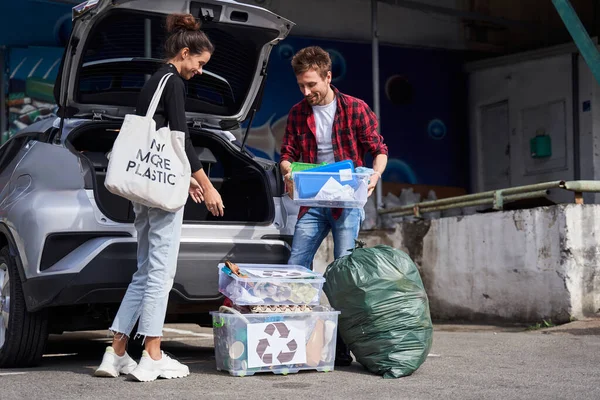 Familjen tar ut avfallslådorna ur bagageluckan — Stockfoto