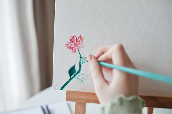 Ragazza bambino che tiene pennello e disegno con le vernici alla tela — Foto Stock