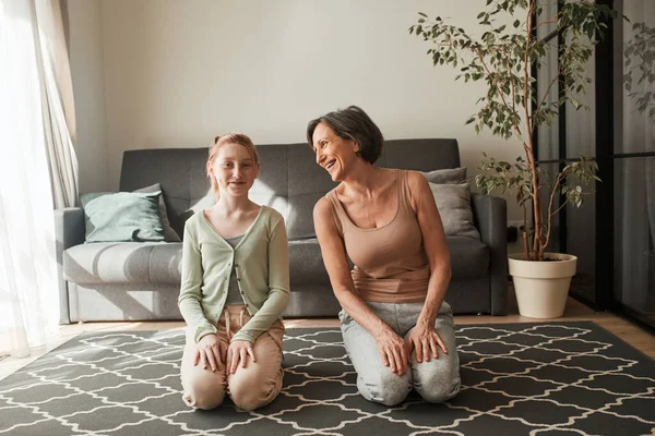 Grandmother talking something to her ginger granddaughter while preparing to the yoga — Φωτογραφία Αρχείου