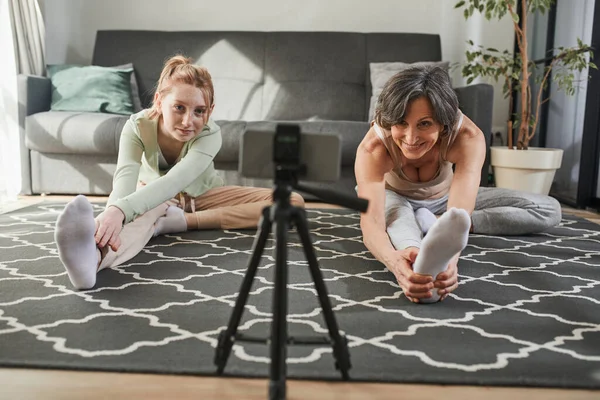 Woman meditating at her cozy living room with her granddaughter while making their blog — Φωτογραφία Αρχείου