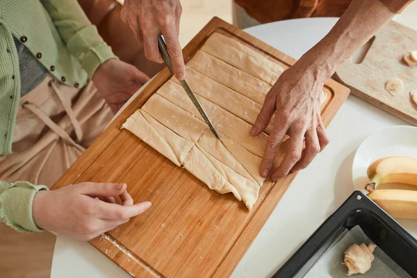 Grandmother chopping dough with the knife while preparing bagels — Stock fotografie
