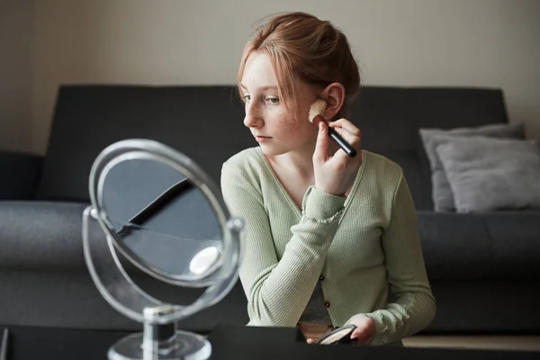 Freckled girl sitting in front of the mirror and preparing makeup — Stock Photo, Image