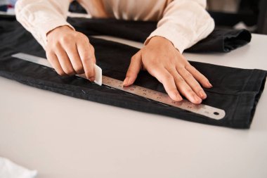 Kadın geri dönüşüm işyerinde çalışırken masada şablon yapıyor