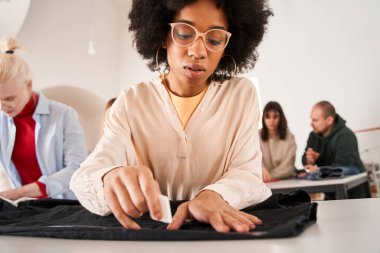 Kadın geri dönüşüm işyerinde çalışırken masada şablon yapıyor
