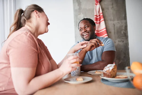 A pár együtt reggelizik, miközben gyümölcslevet iszik és tortát eszik. — Stock Fotó