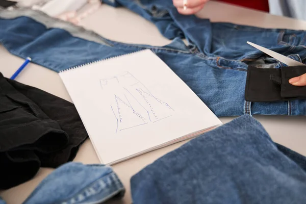 Esboço que coloca na mesa em torno dos jeans diferentes que estão prontos para a re costura — Fotografia de Stock