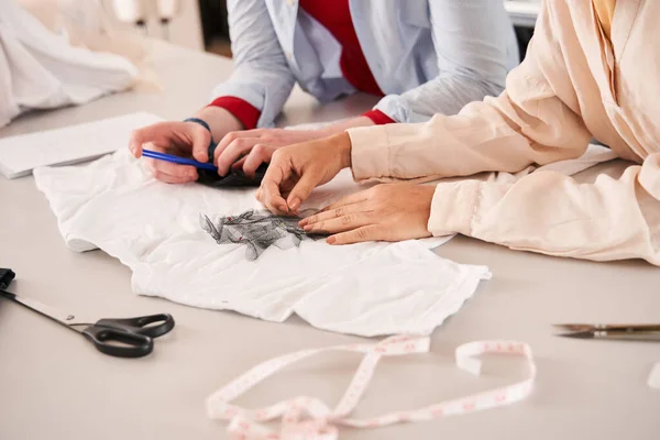 Colleagues applying fabric samples to the clothing while giving new life to the clothes — Stock fotografie