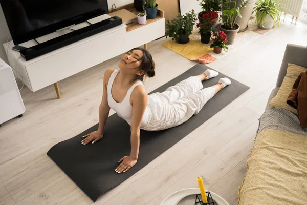 Woman wearing sportswear practicing yoga and doing cobra exercise — Φωτογραφία Αρχείου