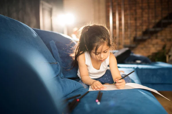 Menina deitada no sofá e desenho imagem de saudação para sua mãe — Fotografia de Stock