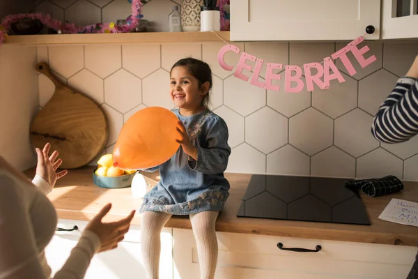 Girl holding orange balloon and waiting for her birthday holiday while sitting