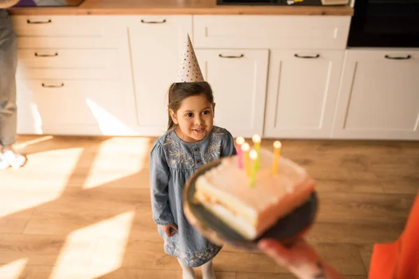 Girl looking at her birthday cake while preparing to blowing out the candles — Φωτογραφία Αρχείου