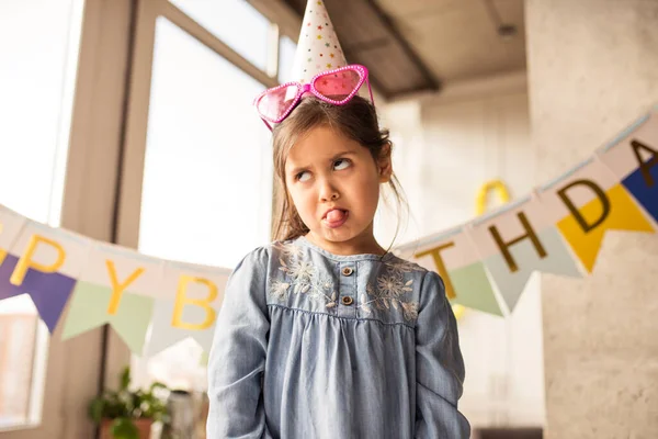 Mädchen macht ein Gesicht, während sie ihre Emotionen während der Feier ihres Geburtstages zeigt — Stockfoto