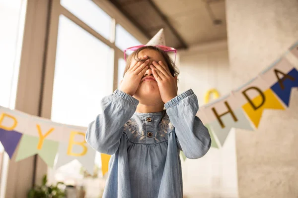 Chica cerró los ojos mientras muecas en la cámara en casa durante su cumpleaños — Foto de Stock