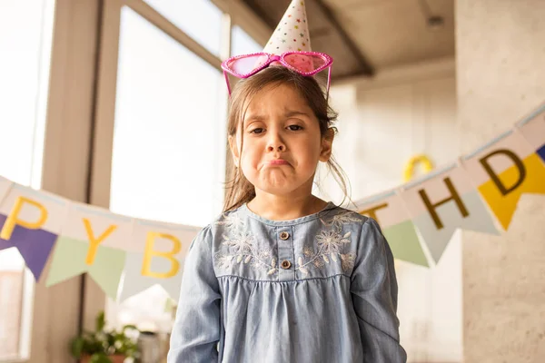 Menina fazendo cara triste ao mostrar suas emoções durante a comemoração de seu aniversário — Fotografia de Stock