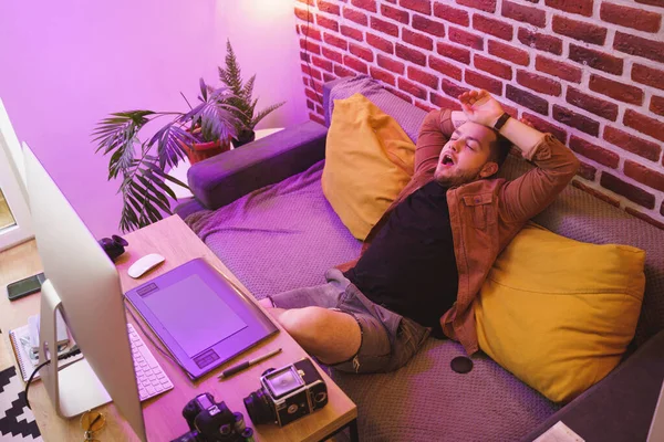 Fotógrafo bocejar e esticar enquanto relaxa em seu local de trabalho — Fotografia de Stock