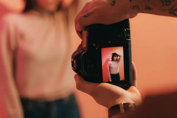 Modelo de pé no estúdio e posando de forma elegante para o fotógrafo masculino — Fotografia de Stock