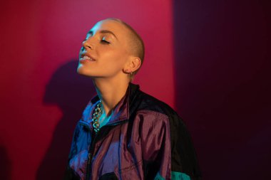 Kısa saçlı, makyajsız, gözleri kapalı bir kadın.