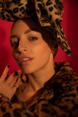 Kameraya bakarken kırmızı arkaplanda poz ver