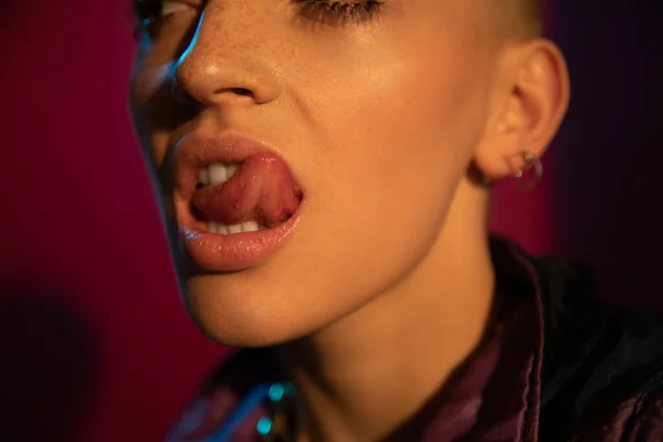 Short haired impudent woman with freckled skin showing her tongue — Stock Photo, Image