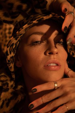 Leopar giyen kadın ağzı açık poz veriyor ve kameraya bakıyor.