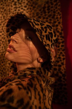 Kameraya bakarken poz veren leopar panama giyen bir kız.