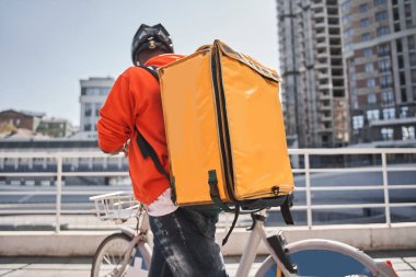 Sırt çantalı bir adam müşteriye giderken akıllı telefon uygulamasına bakıyor.