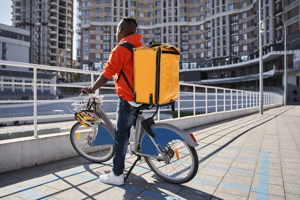 Курьер с тепловым рюкзаком, готовящийся к поездке на велосипеде — стоковое фото