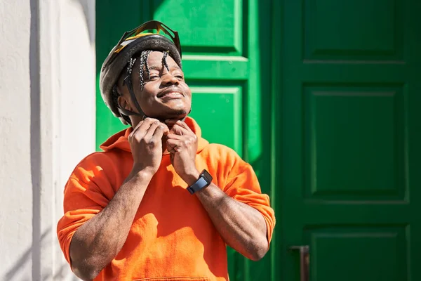 Man dragen helm en levering rugzak staan in de buurt van klanten deur — Stockfoto