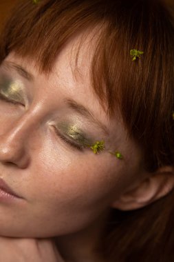 Çekici Kafkasyalı kızıl kadın. Gözleri kapalı. Zevkle gülümsüyor.