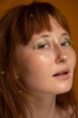 Kızıl saçlı bir kadın kameraya ağzı açık bakıyor.