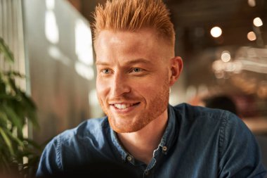 İş başvurusunun önünde dizüstü bilgisayarda oturan ve dinleyen bir adam.