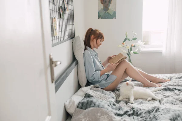 Γυναίκα σπουδάζει στο σπίτι το Σαββατοκύριακο, ενώ κάθεται στο κρεβάτι — Φωτογραφία Αρχείου