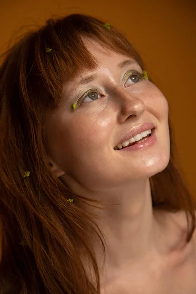 Romantisch meisje met groene bloemen op het haar en gezicht — Stockfoto