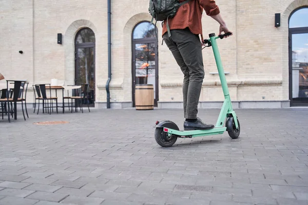 Guy genieten van paardrijden aangedreven scooter in stedelijke stad straat — Stockfoto