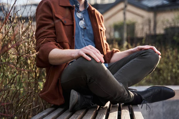 Homme assis jambes croisées sur le banc, pratiquer le yoga et profiter de la méditation — Photo