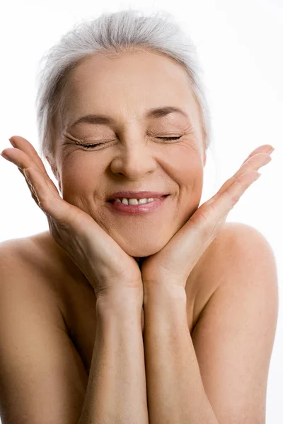 Feliz mujer de pelo gris riendo en voz alta y tomándose de las manos bajo su cara — Foto de Stock